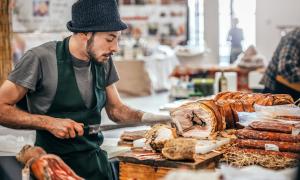 junger Mann schneidet porchetta