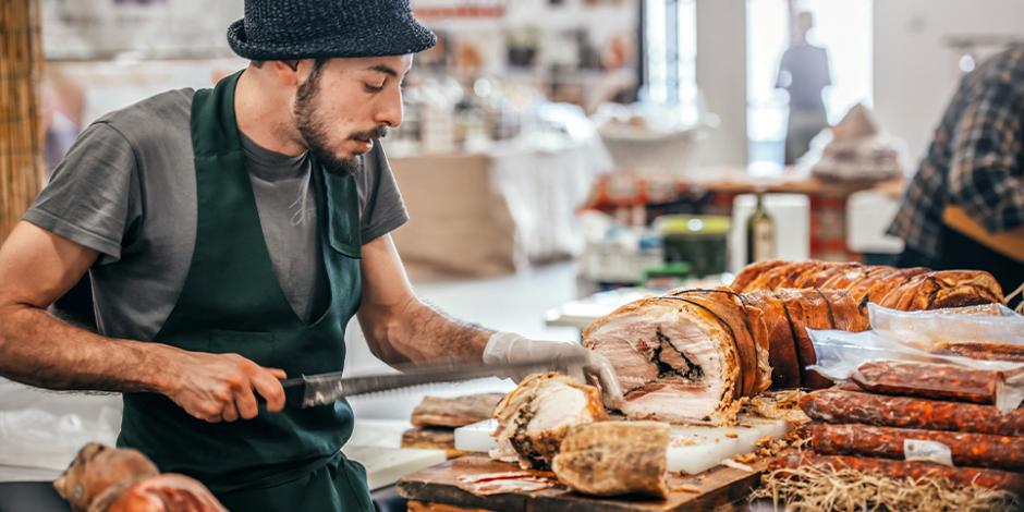 junger Mann schneidet porchetta