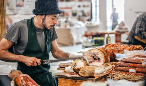 junger Mann schneidet porchetta